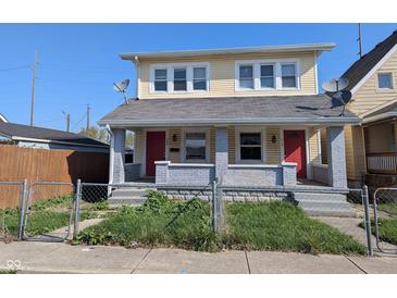 Inviting two-story home with red doors and a chain link fence surrounding the front yard at 408 E Beecher St, Indianapolis, IN 46225