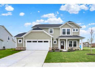 Charming two-story home with a manicured lawn and a two-car garage and inviting covered front porch at 4087 Railhead Ave, Westfield, IN 46074