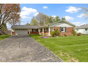 Charming brick home with a well-maintained lawn and attached two-car garage at 5420 E 81St St, Indianapolis, IN 46250
