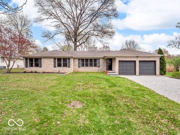 Charming single-story home with a well-manicured lawn, two-car garage, and stone facade at 8621 Manderley Dr, Indianapolis, IN 46240