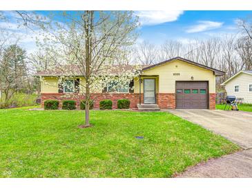 Charming single-story home with well-maintained lawn, brick accents, attached garage and flowering tree in front yard at 9055 Panorama Ct, Indianapolis, IN 46234