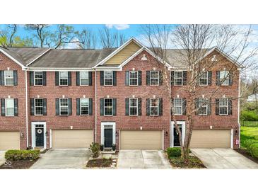 Charming red brick townhomes featuring black shutters, individual garages and well-maintained landscaping at 967 Orlando St, Carmel, IN 46032