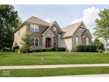 Charming two-story home with a well-manicured lawn and beautiful stone and brick facade, featuring a striking red front door at 1060 Cape Coral Dr, Cicero, IN 46034