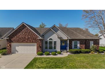 Charming brick and vinyl home featuring a well-manicured lawn and a blue front door at 1927 Westminster Pl, Columbus, IN 47201