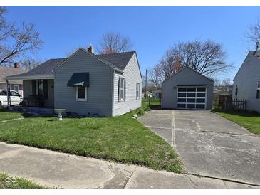 Cozy single-story home with gray siding, a detached garage and a concrete driveway at 2018 Poplar St, Anderson, IN 46012