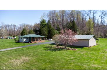 Charming home with a green metal roof, matching outbuilding, and a spacious lawn at 2455 Lenvoil Rd, Martinsville, IN 46151