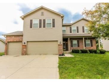 Charming two-story home featuring brick and siding exterior, three-car garage and a well-maintained front lawn at 2599 Liatris Dr, Plainfield, IN 46168