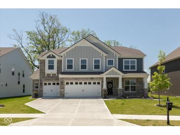 Charming two-story home with a three-car garage, stone accents, and well-manicured front lawn at 4333 Ironclad Dr, Bargersville, IN 46106