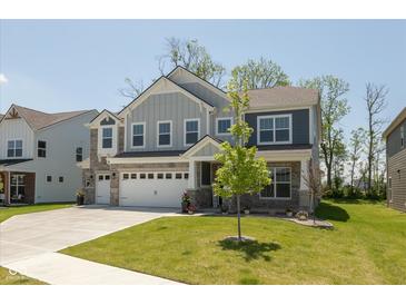 Inviting two-story home featuring a lush lawn, three-car garage and stone accents at 4333 Ironclad Dr, Bargersville, IN 46106