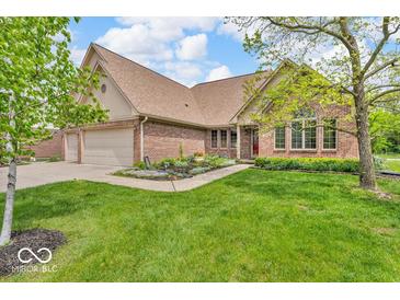 Lovely home with brick facade, three-car garage, and a well-maintained front lawn at 7113 Lakeside Woods Dr, Indianapolis, IN 46278