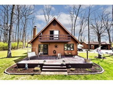 Charming A-frame home featuring a spacious wooden deck, balcony and beautifully landscaped yard with mature trees at 8327 S County Road 825 E, Plainfield, IN 46168