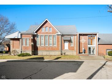 Brick building with gray roof, cross, and statue, set on a sunny street at 840 Cottage Ave, Indianapolis, IN 46203