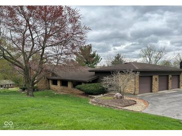 Attractive stone facade on this home with an attached two car garage and a beautifully landscaped front yard at 8801 Ridge Hill Dr, Indianapolis, IN 46217