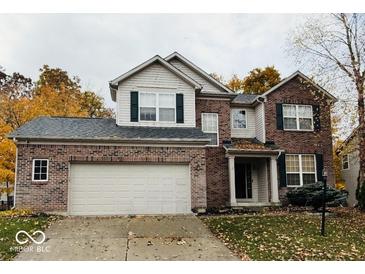 Charming two-story home with brick facade, attached garage and meticulously maintained lawn at 8859 Delaney Dr, Fishers, IN 46038