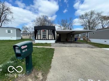 Charming home featuring a covered carport and well-maintained lawn at 9218 Wind River Ct, Indianapolis, IN 46234