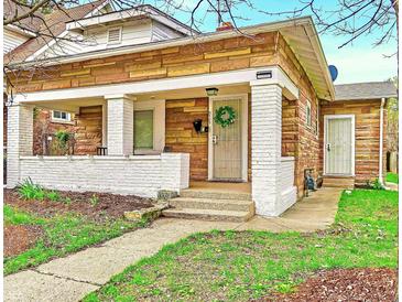 Charming home with a unique stone exterior, covered front porch and well-maintained lawn at 936 N Oxford St, Indianapolis, IN 46201