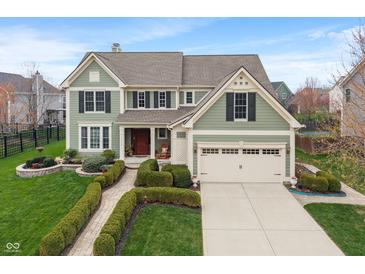 Charming two-story home with a manicured lawn, a two-car garage, and classic architectural details at 14910 Declaration Dr, Westfield, IN 46074