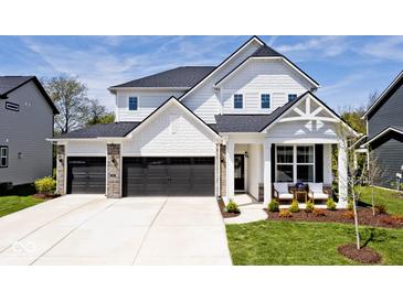 Charming two-story home with a three-car garage and a welcoming front porch seating area at 15341 Montfort Dr, Noblesville, IN 46062