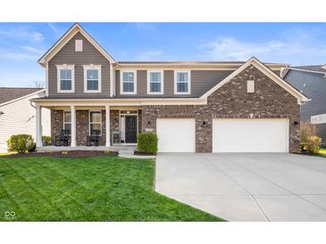 Charming two-story home featuring a manicured lawn and a convenient two-car garage at 15762 Hargray Dr, Noblesville, IN 46062