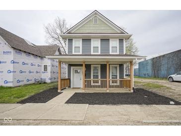 Charming two-story home featuring a welcoming front porch with wood railings and a neatly landscaped yard at 1921 Union St, Indianapolis, IN 46225
