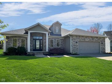 Charming single-story home boasts stone accents, manicured lawn, and inviting front entrance at 1995 Brookfield Ct, Columbus, IN 47201