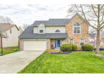 Charming two-story home with brick and vinyl siding, well-manicured lawn, and attached two-car garage at 3051 Firestone Cir, Indianapolis, IN 46234