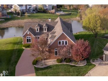 Beautiful brick home with meticulous landscaping, water view, and brick paver driveway at 4052 Diamond Row, Greenwood, IN 46143