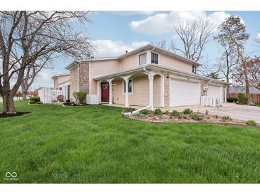 Charming two-story home featuring stone accents, attached garages, and a lush green lawn at 43 Dominion Dr, Zionsville, IN 46077