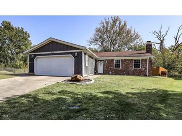 Charming one-story home with brick and siding and attached garage, set on a well-maintained lawn under a clear blue sky at 4421 Greenmeadow Ct, Indianapolis, IN 46235
