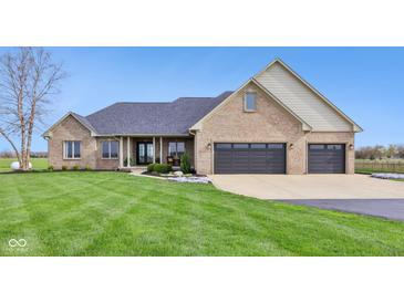 Charming brick home featuring an attached garage, covered porch, and well-manicured lawn at 4634 E 1000 N, Pittsboro, IN 46167