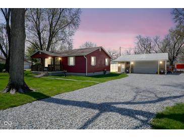 Charming red home features a gravel driveway leading to a detached garage at 502 N Maple St, Ingalls, IN 46048