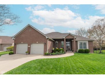 Charming brick home featuring a well-manicured lawn, a two-car garage, and beautiful landscaping at 6081 Boulder Ct, Columbus, IN 47201