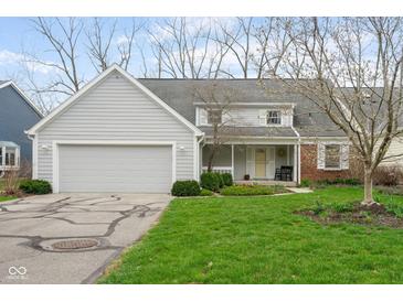 Charming two-story home featuring a well-maintained lawn, inviting porch, and an attached two car garage at 7640 Bay Shore Dr, Indianapolis, IN 46240