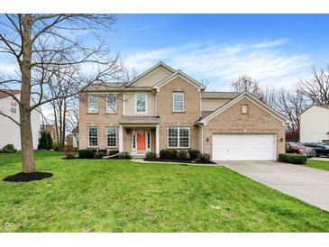 Inviting two-story brick home featuring manicured lawn, mature trees, and a two-car garage at 12027 Sellerton Dr, Fishers, IN 46037