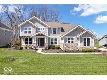 Charming two-story home with a well-manicured lawn, stone accents, and a welcoming front porch at 12598 Coastal Pl, Fishers, IN 46037