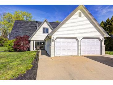 Charming home featuring a two-car garage, manicured lawn, and classic white siding under a blue sky at 138 Fairway Dr, Indianapolis, IN 46260