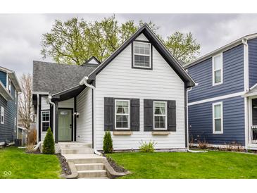 Charming renovated home with modern black and white trim, steps to the front door, and lush green lawn at 341 Sanders St, Indianapolis, IN 46225