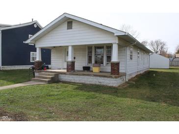 Charming white one-story house featuring a covered front porch and a well-maintained lawn at 548 S Vine St, Indianapolis, IN 46241