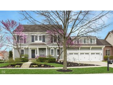 Charming two-story home with a three-car garage and beautifully landscaped front yard at 7613 W Stonegate Dr, Zionsville, IN 46077
