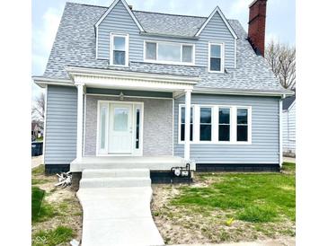 Charming two-story home featuring gray siding, white trim, and a welcoming front porch at 902 E 31St St, Anderson, IN 46016