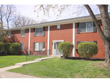 Charming brick townhouse featuring a well-manicured lawn and welcoming blue front door at 928 Hoover Village Dr # 928D, Indianapolis, IN 46260
