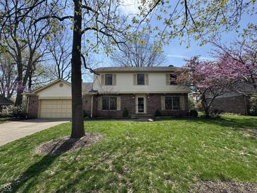 Charming two-story brick and vinyl home featuring a well-maintained lawn and blooming trees at 1235 Cottonwood Ct, Carmel, IN 46033