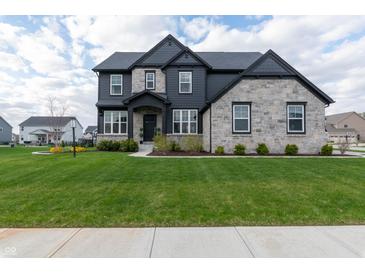 Beautiful two-story home with stone and gray siding, a well-manicured lawn, and professional landscaping at 2280 Meadow Crk, Avon, IN 46123