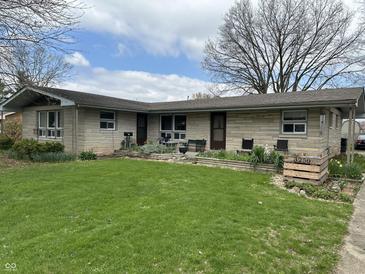 Charming single-story home featuring a well-manicured lawn and stone accents at 3250 Hillcrest Dr, Columbus, IN 47203