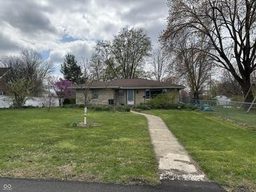 Charming one-story home with a well-manicured front lawn and a welcoming walkway leading to the front door at 3315 Hillcrest Dr, Columbus, IN 47203