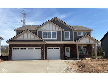 Charming two-story home featuring a brick facade, attached two-car garage and covered entryway at 4235 Brocket Dr, Greenwood, IN 46143