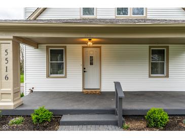 Inviting front entrance featuring a white door, decorative light fixture, and charming landscaping at 5516 S Randolph St, Indianapolis, IN 46227