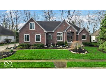 Charming brick home featuring manicured lawn and a well-designed garden bed at the front entrance at 5861 Dawnwood Dr, Carmel, IN 46033
