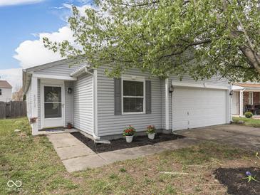 Charming home exterior with gray siding, a two car garage and well-kept landscaping at 6212 Monteo Dr, Indianapolis, IN 46217