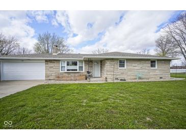 Charming stone facade ranch home with an attached garage and a well-manicured lawn at 712 Valley Dr, Anderson, IN 46011
